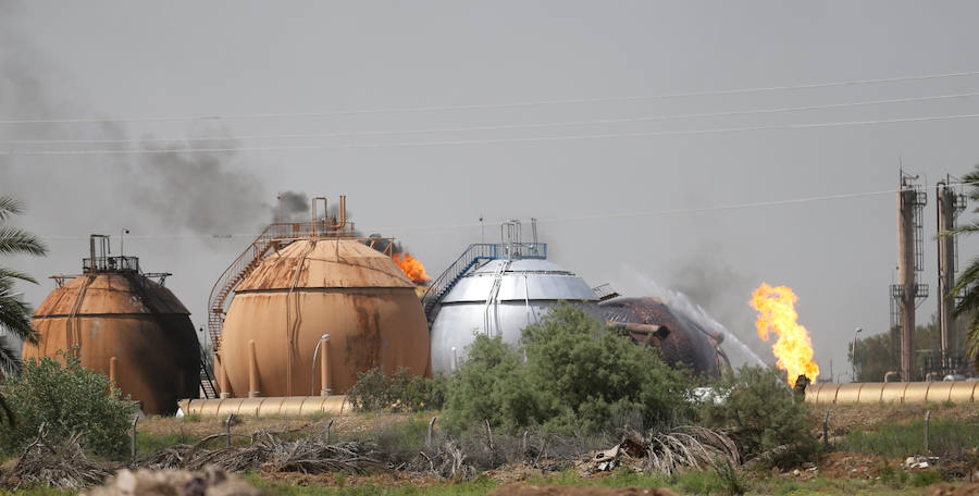 El humo se eleva desde los tanques de almacenamiento de gas después de un ataque con bomba en Taji, en las afueras del norte de Bagdad (Irak).