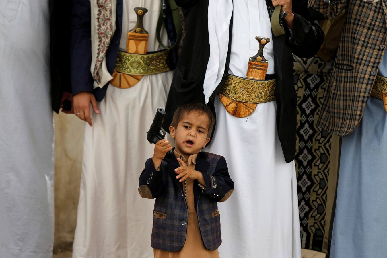 Un niño, con la pistola de su padre, en una muestra de apoyo al movimiento Houthi en Sanaa (Yemen).