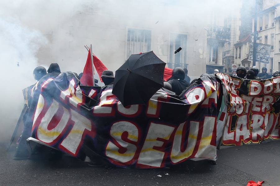 Un manifestante se protege con un paraguas durante los enfrentamientos con la policía antidisturbios en una marcha antifascista para conmemorar el tercer aniversario de la muerte del joven activista de extrema izquierda Clemente Meric, que murió en una pelea con cabezas rapadas en el centro de París en junio de 2013.
