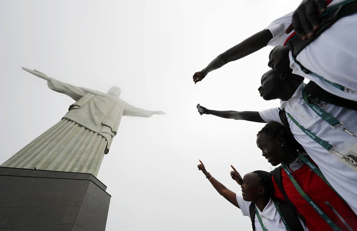 Miembros del 'equipo olímpico de los refugiados' posan junto al Cirsto Redentor en Río de Janeiro. /REUTERS/Kai Pfaffenbach