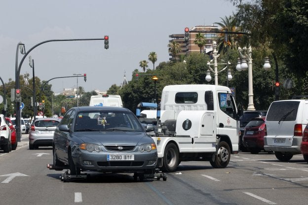 Una grúa municipal se lleva un coche en el paseo de la Alameda. 