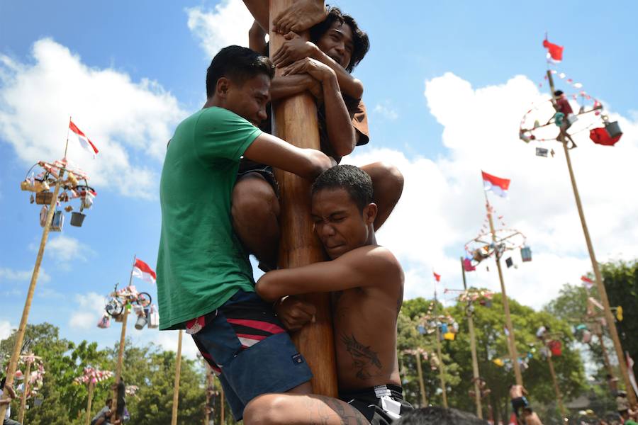 Tailanda celebra su Día de la Independencia de una manera muy peculiar: colocan en vertical los troncos talados de nogales que engrasan con aceite para dificultar la llegada a la cima en la que se encuentran varios premios. 
