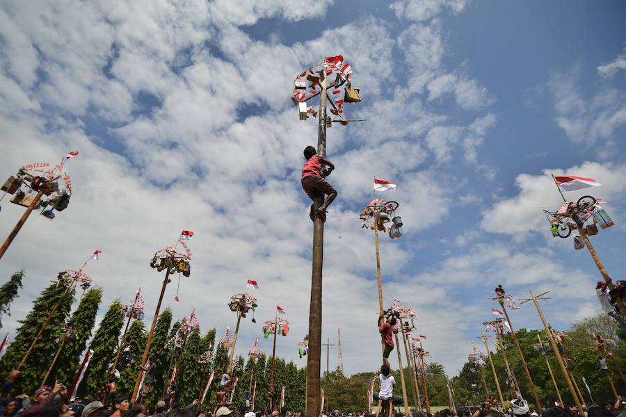 Tailanda celebra su Día de la Independencia de una manera muy peculiar: colocan en vertical los troncos talados de nogales que engrasan con aceite para dificultar la llegada a la cima en la que se encuentran varios premios. 