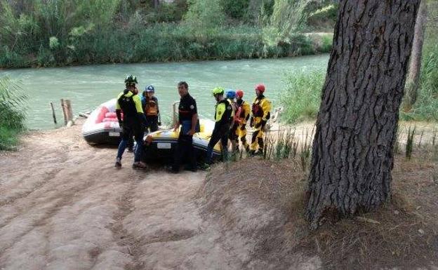 Dos equipos de rescate, ayer, en la orilla del río Cabriel.