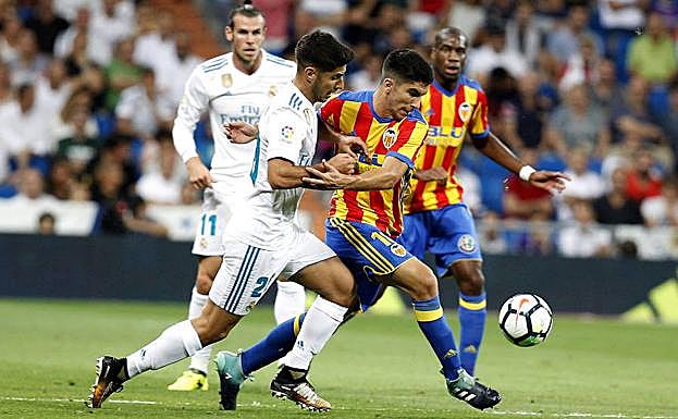 Soler y Asensio pugnan por el balón