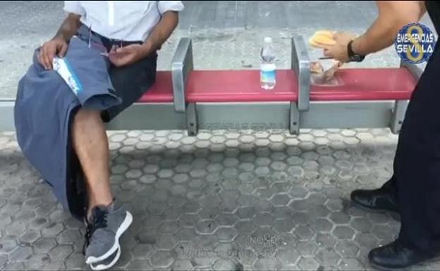 Un policía local de Sevilla le prepara un bocadillo a un hombre desfallecido