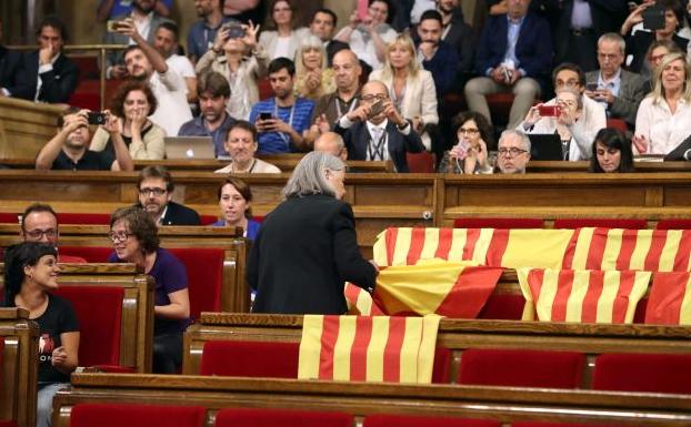 Àngels Martínez quitando las banderas de España en el Parlamento catalán.