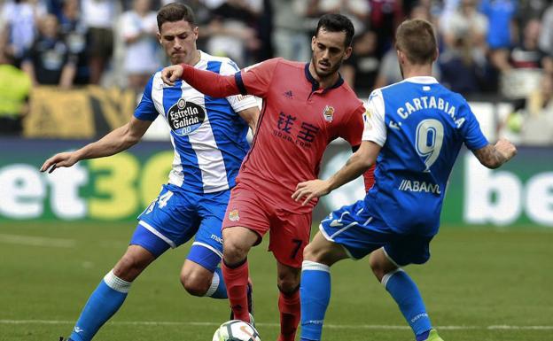 Juanmi (c.) disputa un balón con los defensas deportivistas.