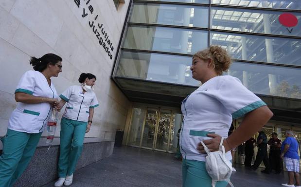 Mujeres con máscaras para trabajar esta mañana en la Ciudad de la Justicia de Valencia. 