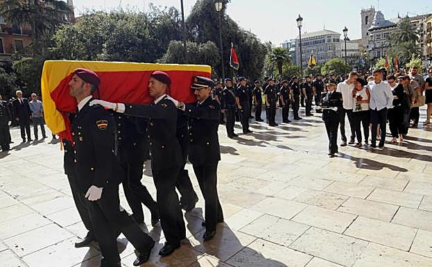 Compañeros del subinspector portan el féretro hasta la Catedral de Valencia.