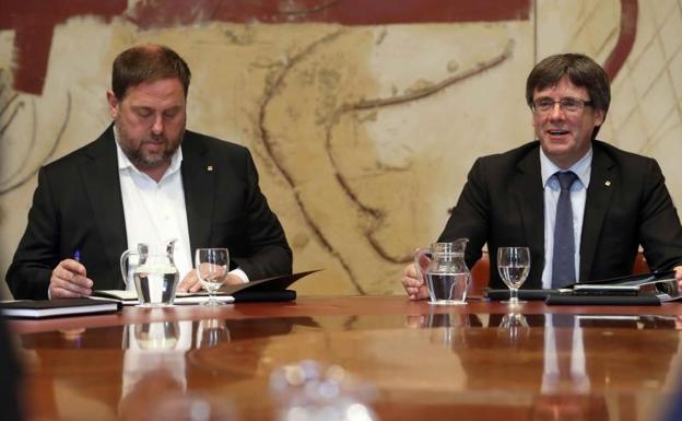 El presidente de la Generalitat, Carles Puigdemont (c), junto al vicepresidente, Oriol Junqueras (i).