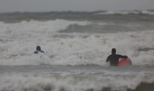 Dos deportistas desoyen las recomendaciones y se internan en la Malvarrosa en pleno temporal. 