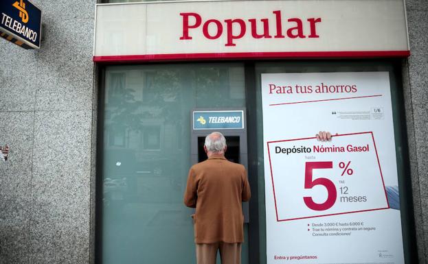 Un hombre, en el cajero de una sede del Popular.