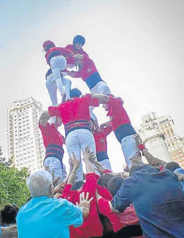 Los integrantes de la 'colla castellera' levantan una torre humana en pleno centro de Madrid. 