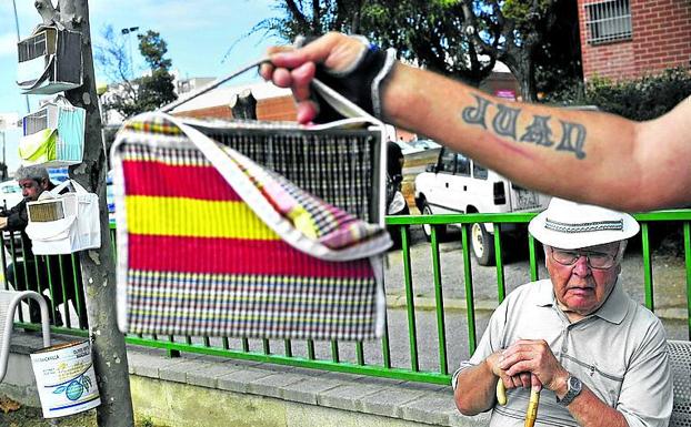 Pájaros de paseo. Juan Pérez muestra la jaula de su canario en las pistas de petanca del ‘casal d’avis’, el centro de mayores de Badia.