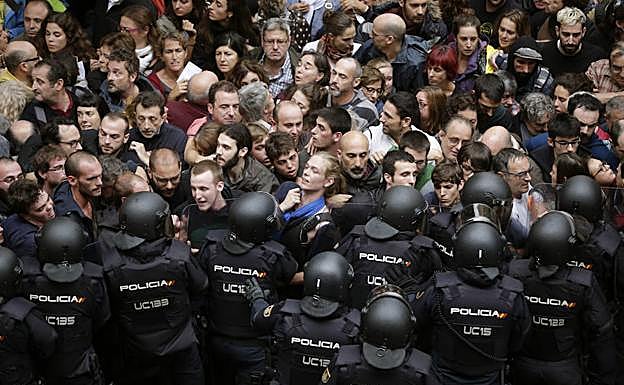 Antidisturbios de la Policía Nacional forman ayer un cordón de seguridad en los alrededores del colegio Ramón Llull de Barcelona.