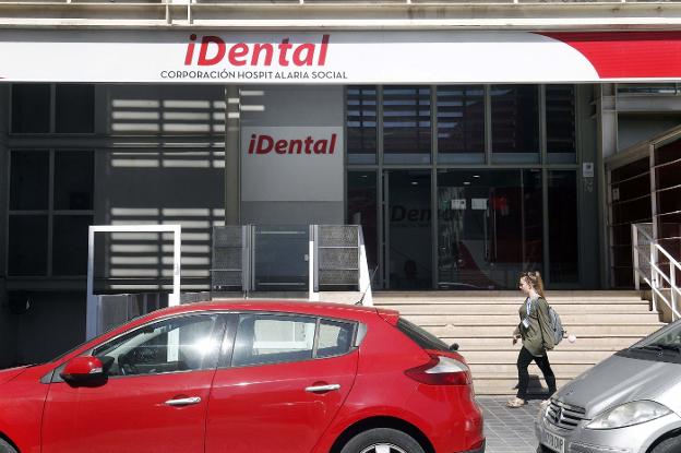 Una joven camina por la puerta de uno de los cuatro centros de Idental en Valencia. 