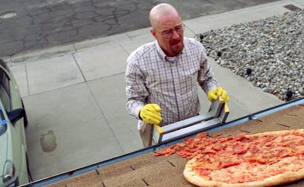 Walter White recoge la pizza sobre el tejado de la casa en una escena de la serie.