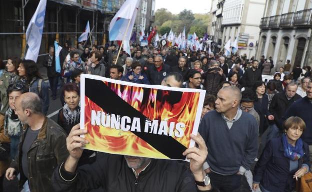 Un hombre porta un cartel con el lema 'Nunca mais', durante la concentración.