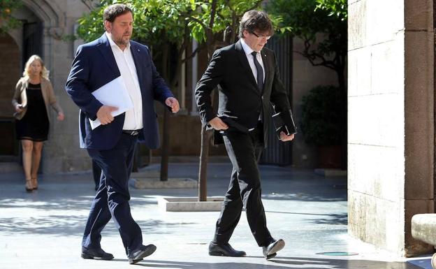 Puigdemont (d) y Junqueras caminan. 