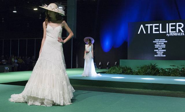La vicepresidenta del Consell, Mónica Oltra, ha visitado la feria Fiesta y Boda y se ha probado una pieza de indumentaria valenciana en un expositor.