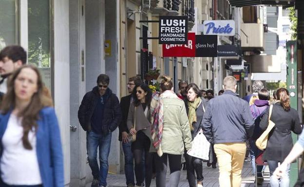 Gente paseando en una zona comercial. 