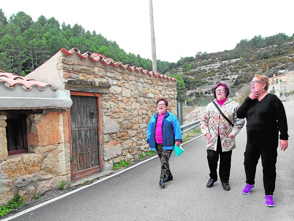 Las tres vecinas pasean por la carretera que atraviesa la pedanía. 