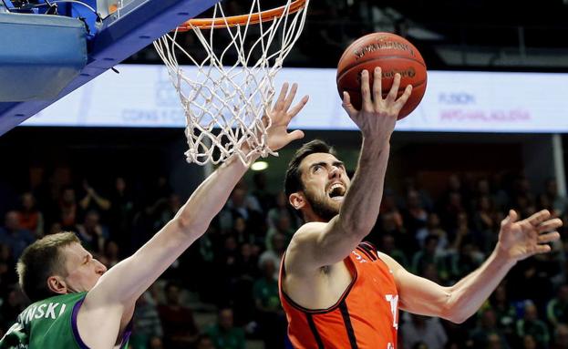 El alero de Valencia Basket, Joan Sastre, intenta encestar ante el alero polaco de Unicaja, Adam Waczynski.