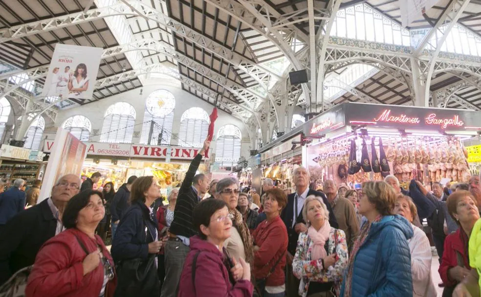 Un guía da explicaciones a un grupo de turistas en uno de los pasillos del Mercado Central.