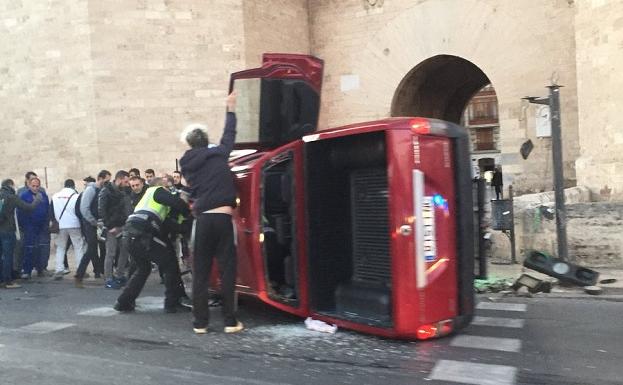 Vehículo volcado ante las Torres de Serranos.