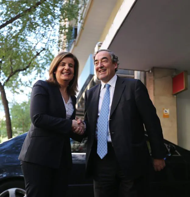 Fátima Báñez estrecha la mano a Juan Rosell. 
