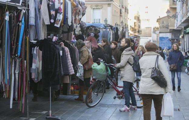 Compradores pasean entre los puestos del mercadillo del Cabanyal. 