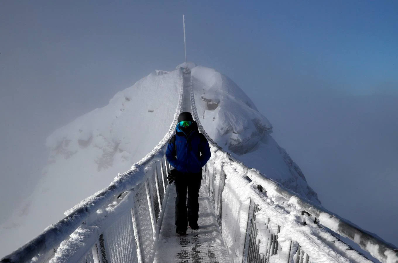 Un 'snowboarder' camina en el puente Peak Walk en Glacier 3000, en Les Diablerets (Suiza). 