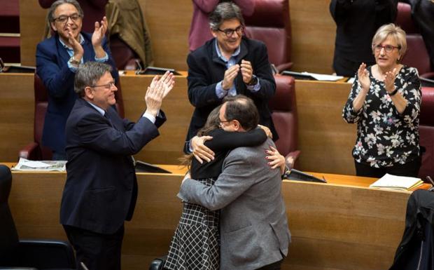 Soler y Oltra se abrazan en Les Corts tras la aprobación de los Presupuestos. 