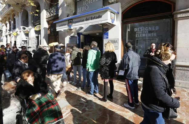 Colas de clientes a última hora de la mañana de ayer en Lotería Bello, en la plaza del Ayuntamiento de Valencia. 