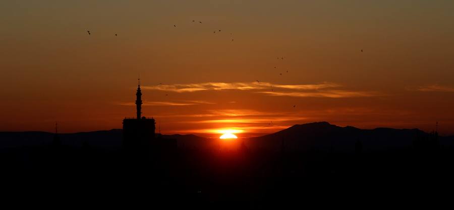 Puesta de sol con la silueta de El Miguelete en primer plano durante el día de Navidad en el que se ha vivido una jornada de temperaturas primaverales.