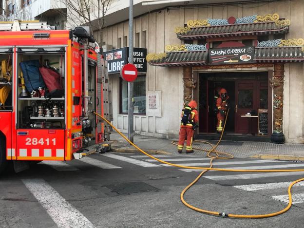 Los bomberos entran al restaurante afectado por el fuego. 