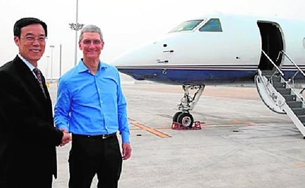 El consejero delegado de Apple, Tim Cook (derecha), se despide antes de subir a su avión.