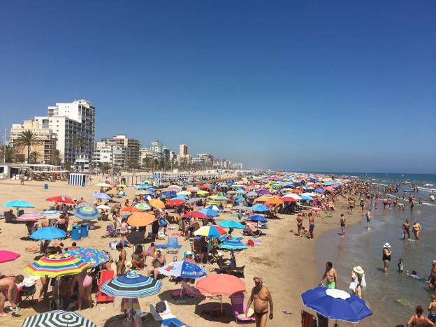 Miles de turistas disfrutan de una jornada de sol y playa el pasado mes de julio en Gandia. 