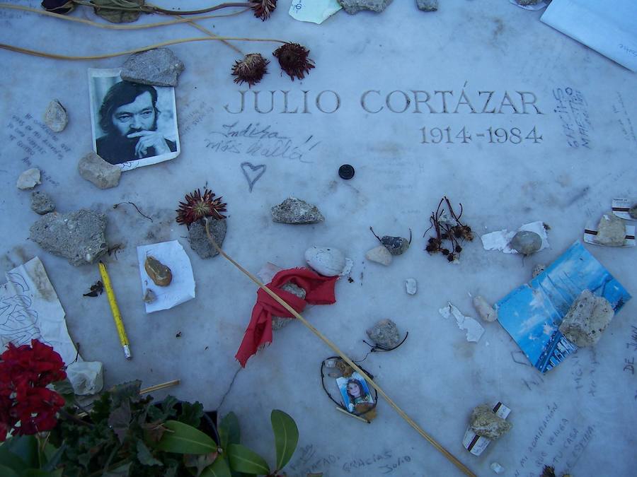 JULIO CORTÁZAR: En el cementerio parisino de Montparnasse, resguardado por una alta torre de 200 metros de altura, el nombre del escritor argentino Julio Cortázar se esconde entre la multitud de tumbas anónimas, junto al de la que fue su compañera, la artista canadiense Carol Dunlop. Sobre ella, los visitantes depositan libros, folletos, cigarros, tickets de metro, flores y mensajes garabateados sobre el mármol.