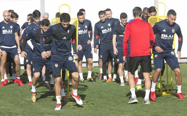  La plantilla del Valencia, realizando los primeros ejercicios del entrenamiento de ayer. 