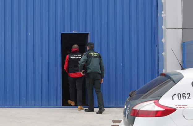 Dos guardias civiles entran en la nave de Picassent donde cultivaban marihuana. 