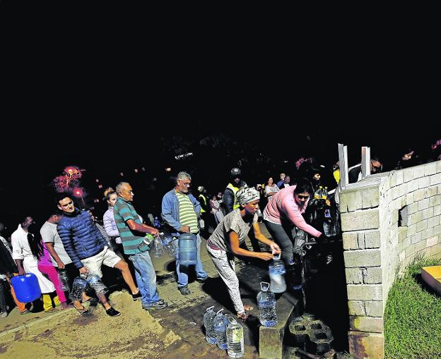 Vecinos de Ciudad del
Cabo hacen cola junto
a las fuentes de agua
potable en busca de
suministro. 