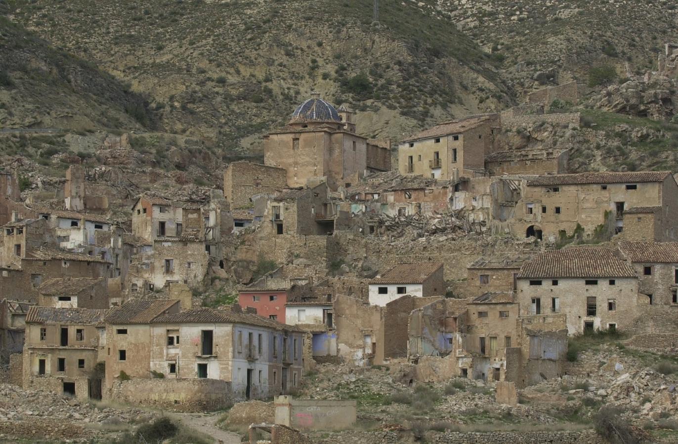 Domeño Viejo no es realmente un pueblo. Se trata del territorio donde se encontraba originalmente la localidad valenciana Domeño, a unos 30 kilómetros de la disposición actual, antes de la construcción del embalse de Loriguilla en 1979. Los habitantes de este 'viejo' municipio se vieron obligados a abandonar sus casas debido al alto riesgo de inundaciones que suponía la construcción del pantano. En la actualidad nada queda de los edificios locales que observamos en la fotografía tomada en 2001. Un castillo musulmán, un gran salto de agua y el cementerio fue lo único que quedó en pie después de su total derribo. Y es justo este camposanto el protagonista principal en esta localidad abandonada. En diversos blogs dedicados al estudio de hechos paranormales cuentan que la forma física de este cementerio ha sido alterada por la sucesión de diversos rituales satánicos. Hasta allí se siguen acercando escépticos curiosos que no dejan pasar la oportunidad de alimentar viejas creencias de fantasmas y seres del otro mundo.