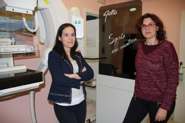 Begoña Patiño y Raquel Ordúñez, junto al mamógrafo ubicado en el Centro de Salud Pública de Dénia y al lema de su proyecto. 