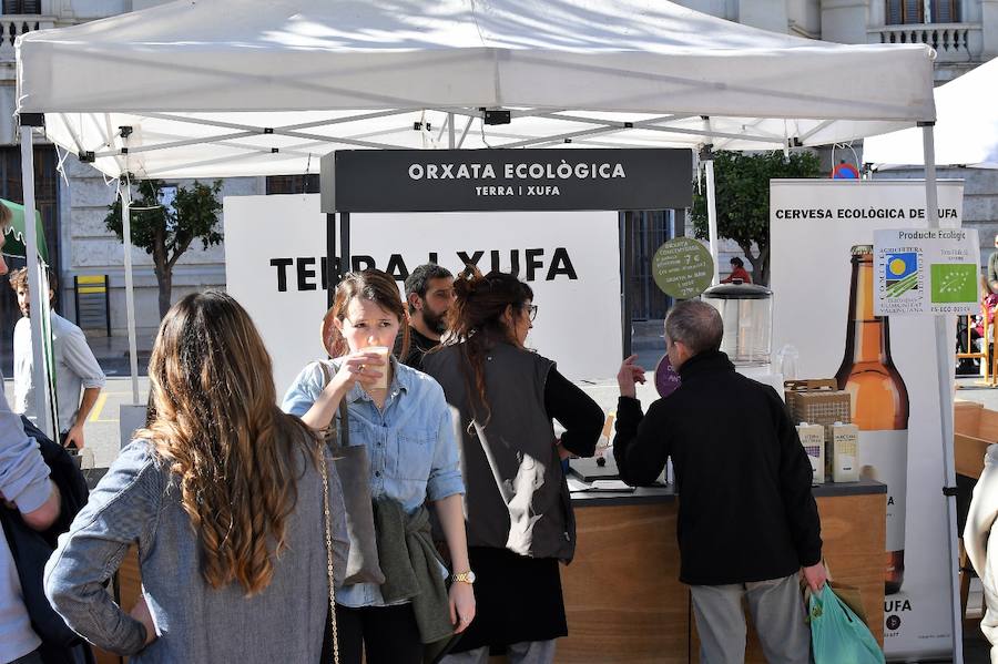 La plaza del Ayuntamiento de Valencia ha acogido este domingo la tercera edición del mercado de proximidad 'De l'Horta a la Plaça', en el que 55 productores y diez puestos de distribución han compartido el céntrico enclave de la ciudad con talleres, charlas y música. La propuesta de fomento de la producción agrícola de proximidad organizada por la Concejalía de Agricultura y Pueblos de Valencia arrancó a las 10 de la mañana con actividades divulgativas, culturales y lúdicas.