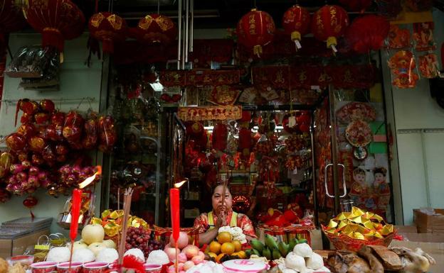 Una mujer tailandesa de origen chino presenta regalos a sus ancestros durante el Año Nuevo Lunar chino.