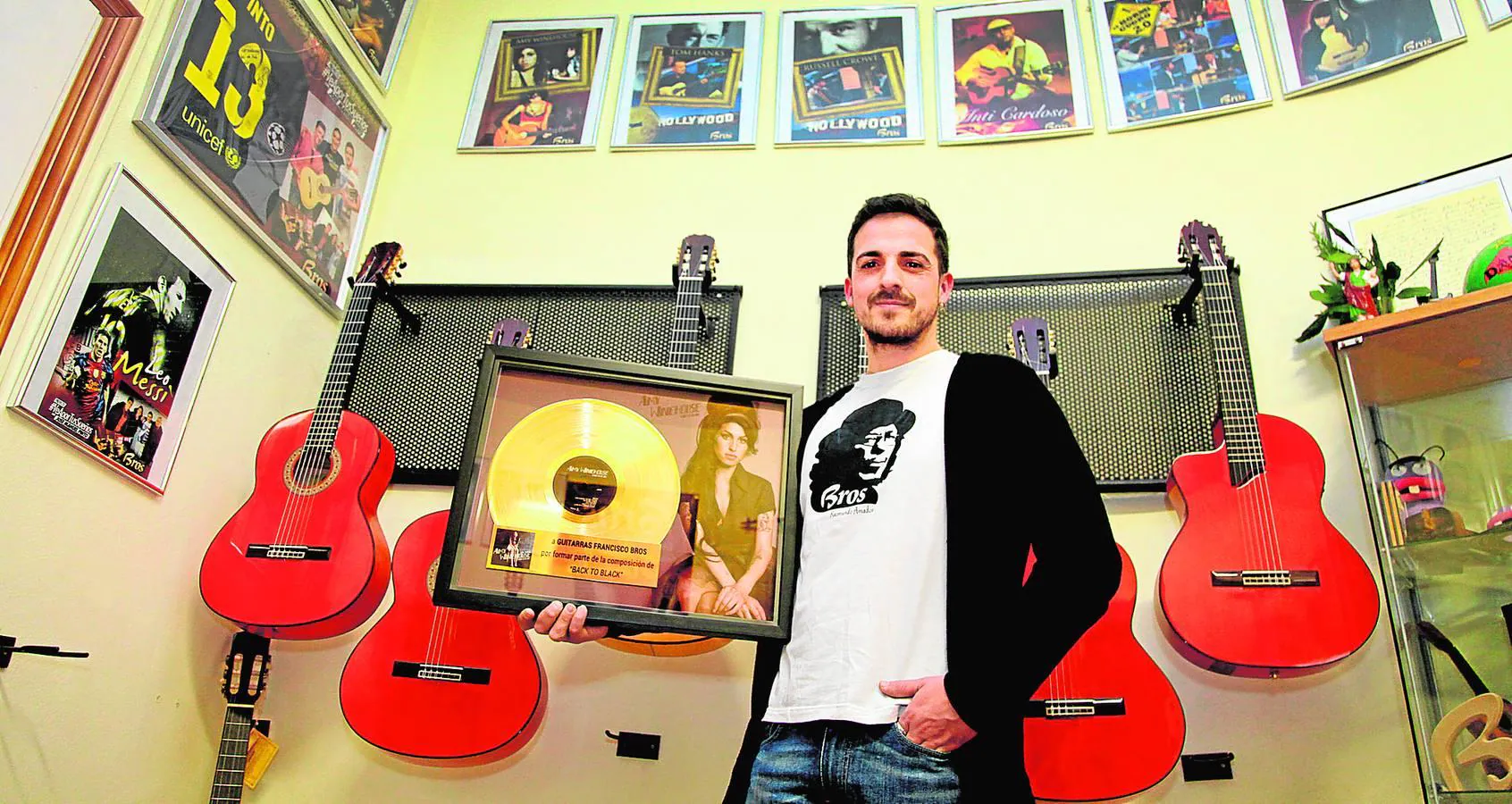 Adam Broseta, junto a varias de las guitarras que fabrican en Gata, muestra el recuerdo del disco de Amy Winehouse. 