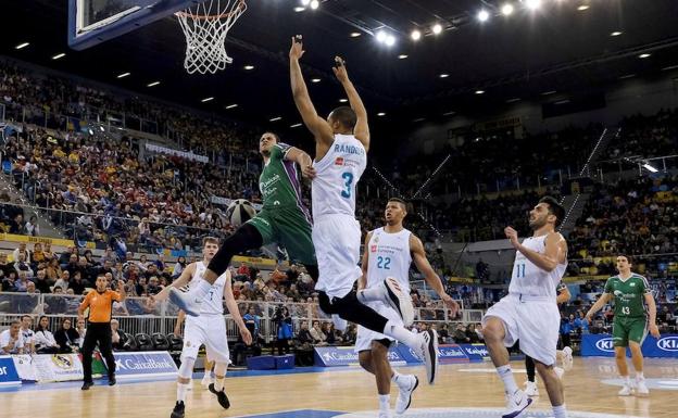 El base de Unicaja, Ray McCallum, entra a canasta defendido por Anthony Randolph del Real Madrid.