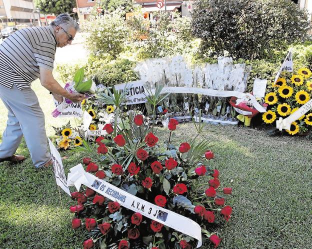 Un hombre deposita unas flores en el jardín sobre el túnel del accidente. 